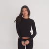 model moving in Caeli long sleeve thermal top, showing stretch, lightweight feel, and body-skimming fit **black
