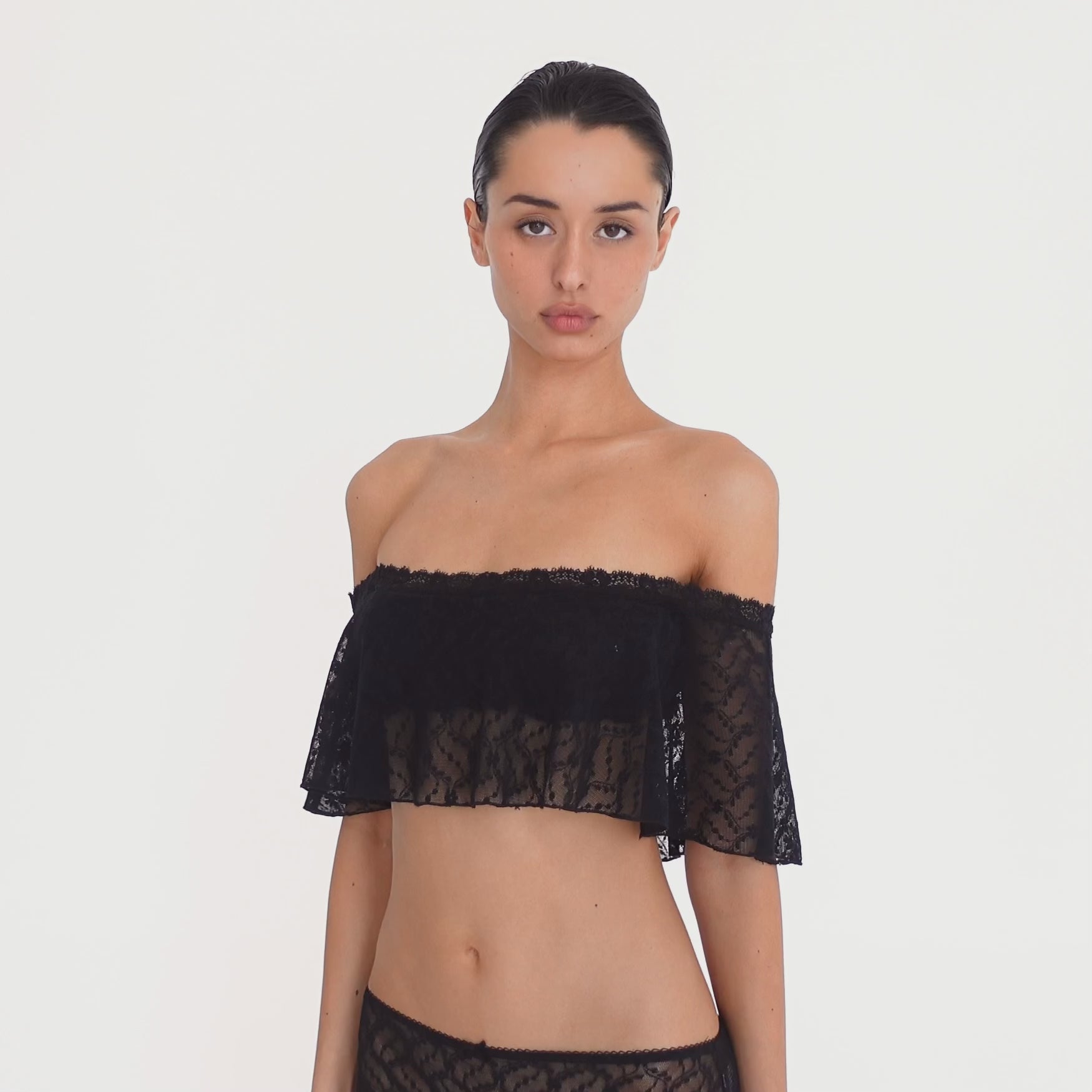 video: Model wearing the Liulu Top in black, showing the movement, sheer floral lace and off shoulder ruffle silhouette from multiple angles **black
