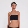 Video: Model turns and poses in the Meili Bandeau in Black, showing the cropped strapless fit, all-over ruching and fitted silhouette from multiple angles. **black
