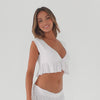 Model wearing white cropped ruffle top and matching skirt, demonstrating movement, fabric drape, and ruffle hem structure **white