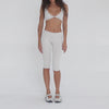 Model showcases Clio Capri in sand, walking and turning to display the cropped ribbed fit, high waistband, and sleek stretch fabric from all angles. **sand