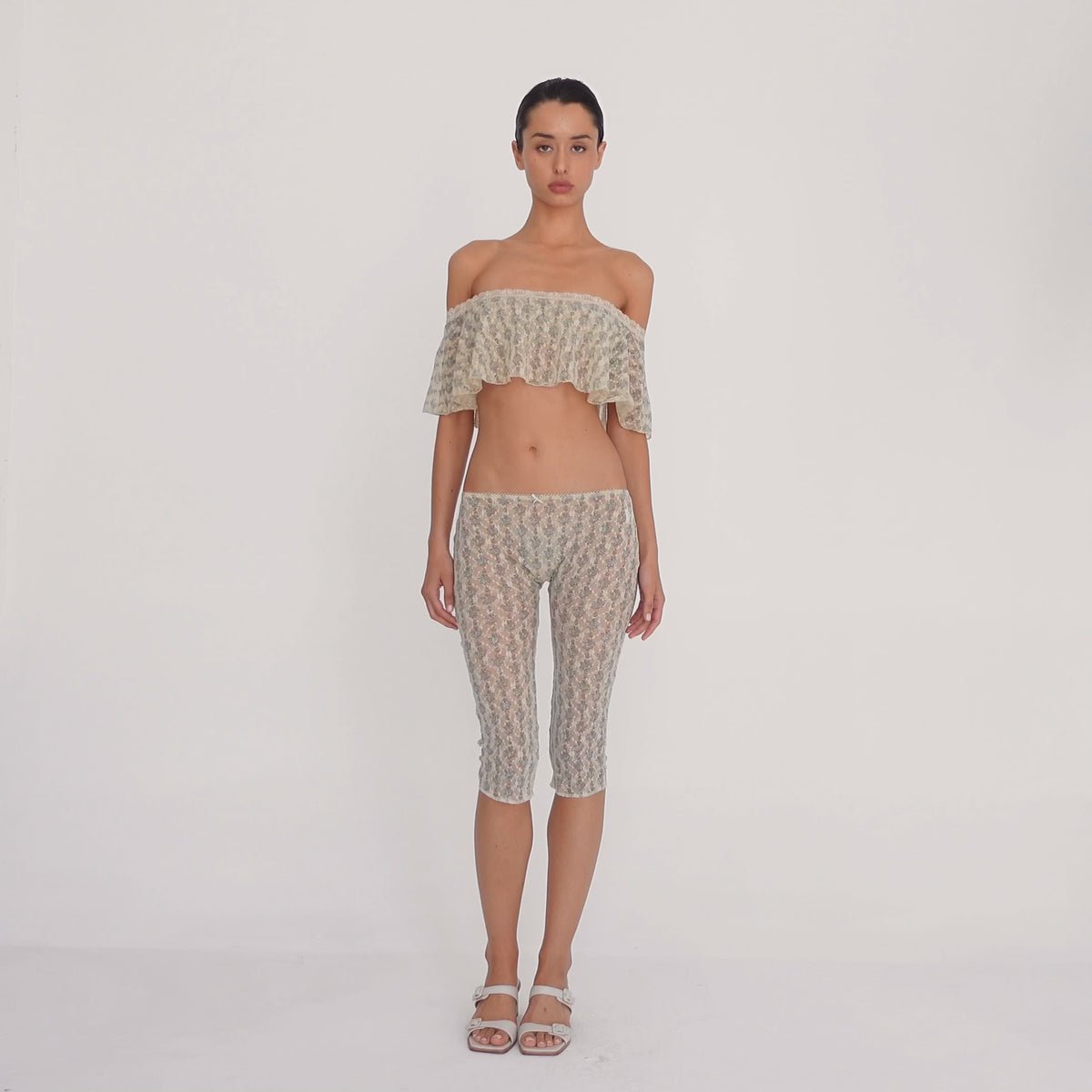Model moves to show the cream sheer floral lace Lyli Capri and matching off shoulder top from multiple angles, highlighting the fit, length, and transparency of the lace. **sky blossom