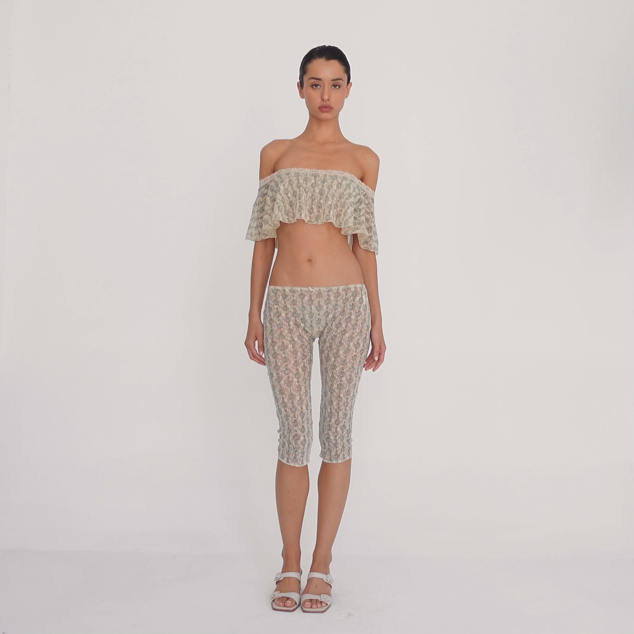 Model moves to show the cream sheer floral lace Lyli Capri and matching off shoulder top from multiple angles, highlighting the fit, length, and transparency of the lace. **sky blossom