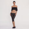 Video: Model wearing the sheer black floral lace off-the-shoulder cropped top and matching fitted capri pants, displaying the outfit from multiple angles to show its fit, transparency, lace pattern, and movement. **black