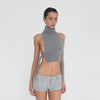 Video: Model turns and poses in the Nula Short in Dove, showing the low rise waistband, belt loops, tailored construction and micro-short silhouette from multiple angles. **dove