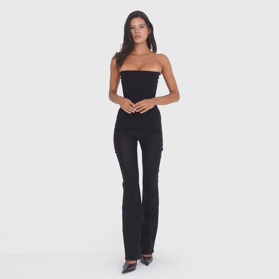 Video: Model wearing and moving in the ARE YOU AM I Sunniva Pant in black, a sheer low-rise pant with a slim flared silhouette **black
