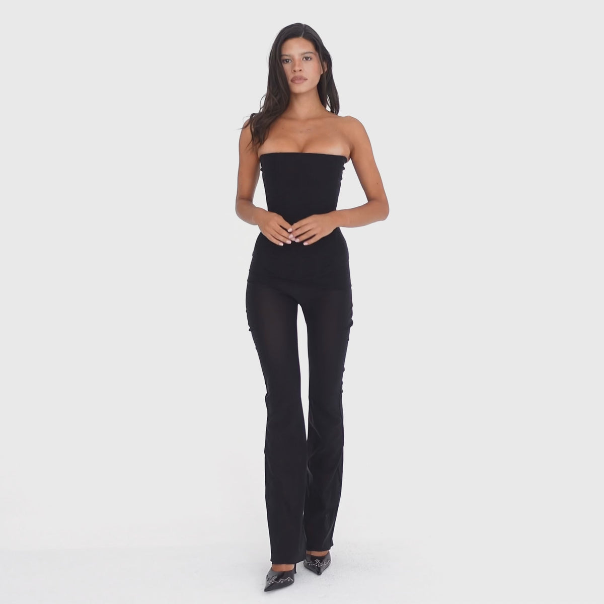 Video: Model wearing and moving in the ARE YOU AM I Sunniva Pant in black, a sheer low-rise pant with a slim flared silhouette **black