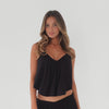 Model wearing black cropped swing cami top with adjustable straps and relaxed drape, shown in motion to highlight lightweight fabric and fluid movement. **black
