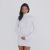 Video: Model wearing the ARE YOU AM I Denz Dress in white, turning to show the fitted long-sleeve turtleneck mini dress and dramatic open-back design **white
