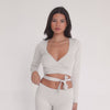 Model moving and stretching in sand ribbed active wrap top with deep V neckline and adjustable wrap ties **sand