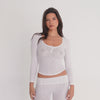 Model modeling a sheer white long sleeve scoop neck henley top with three buttons, shown from front, side, and back angles while posing. **white