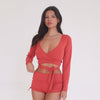 Model moving in Nuka ribbed wrap top in cayenne, showing stretch, wrap ties, and active fit **cayenne