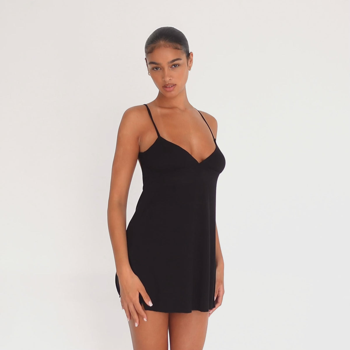 Model wearing the Ysa Dress in black — soft modal mini with spaghetti straps, bias-cut for a fluid drape and low open back.**black