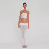 Video: Model turns and poses in the Meili Pant in White, showing the low rise fit, wide ruched fold-over waistband, sheer fabric and subtly flared leg. **white