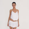 Video: Model turning to show the white Taela Skirt from multiple angles, highlighting its low rise ruched waistband, flared micro length and soft draped finish **white