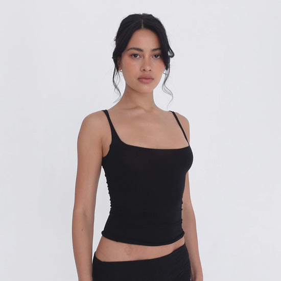 Model turning slowly in the black Elix Tank, showing the square neckline from the front, the fitted side profile and the low scoop back **black