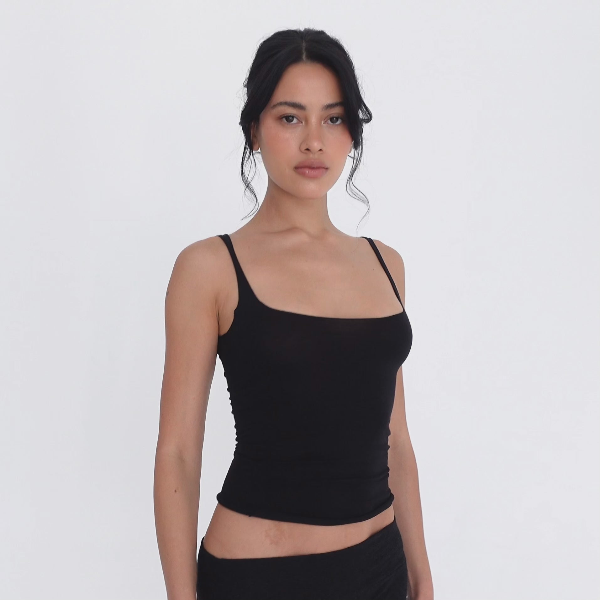 Model turning slowly in the black Elix Tank, showing the square neckline from the front, the fitted side profile and the low scoop back **black
