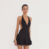 Video: Model turning to show the black Atalanta Dress from multiple angles, including its plunging V neckline, open back, halter ties and double ruffle hem **black