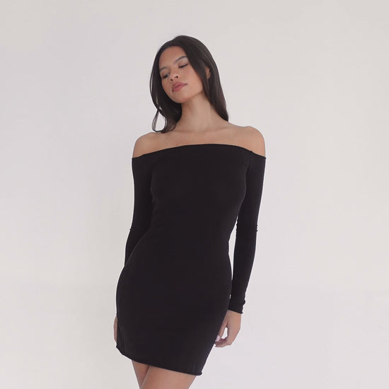 Model wearing a black off-the-shoulder long sleeve fitted mini dress, shown from front, side, and back to highlight neckline, silhouette, and fabric movement. **black